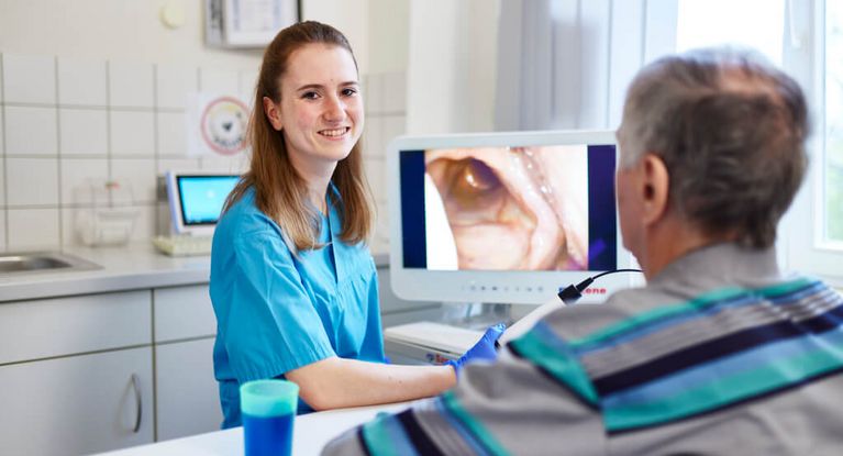 Pflegekraft bespricht mit Patienten Diagnose am Bildschirm