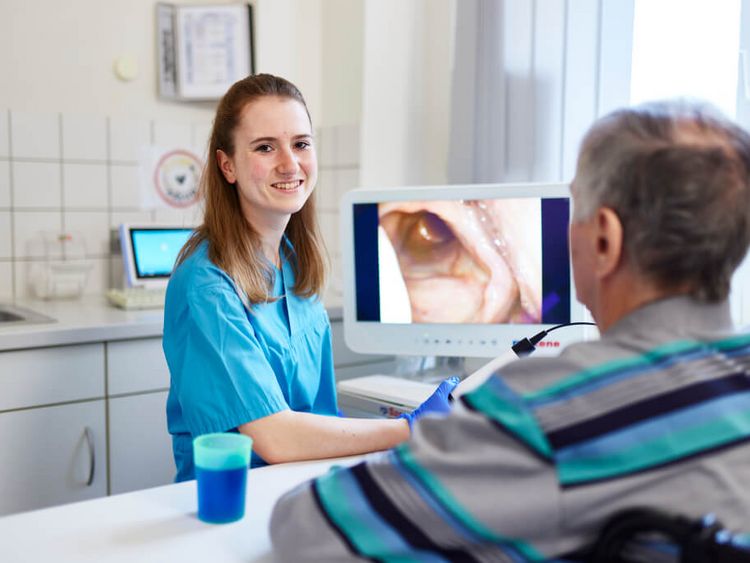Pflegekraft bespricht mit Patienten Diagnose am Bildschirm