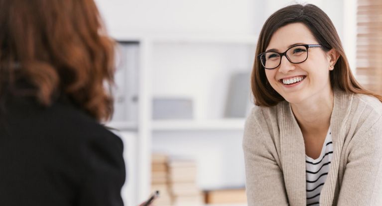 Freundliche Theapeutin spricht mit Patientin