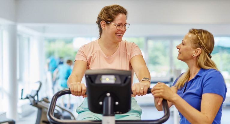 Frau auf Ergometer bei Geräteeinweisung