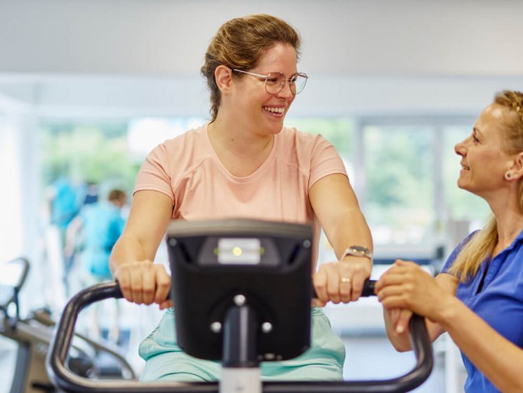 Frau auf Ergometer bei Geräteeinweisung