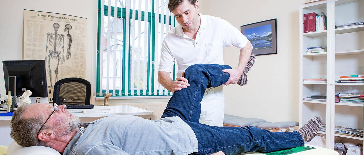 Arzt untersucht Knie eines Patienten