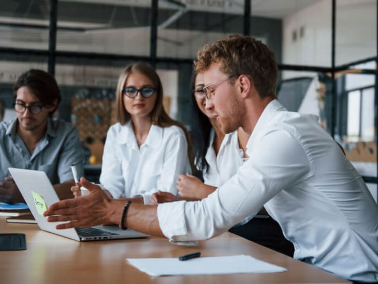Junge Menschen sitzen zusammen im Büro und besprechen ein Projekt