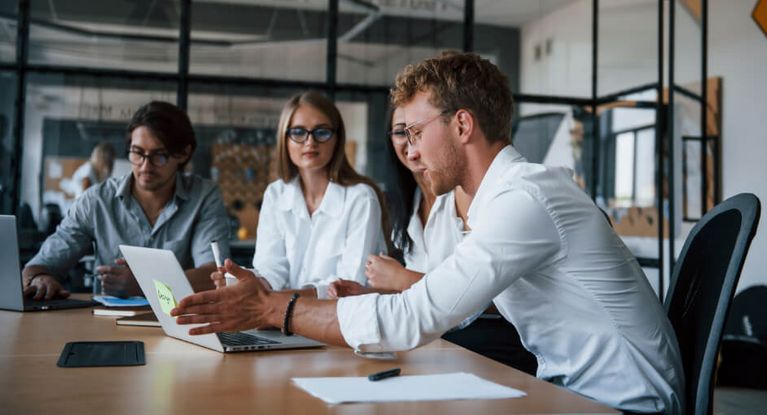 Junge Menschen sitzen zusammen im Büro und besprechen ein Projekt