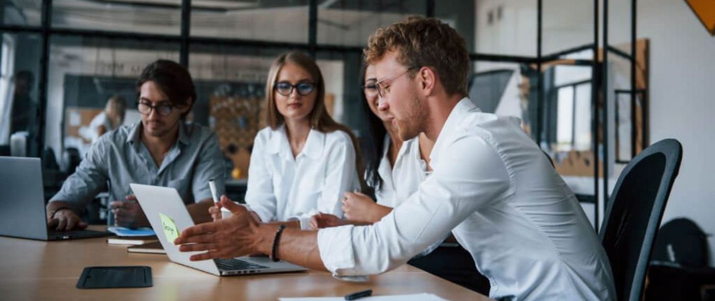 Junge Menschen sitzen zusammen im Büro und besprechen ein Projekt