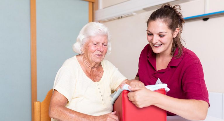 Therapeutin unterstützt ältere Patientin in der Ergotherapie