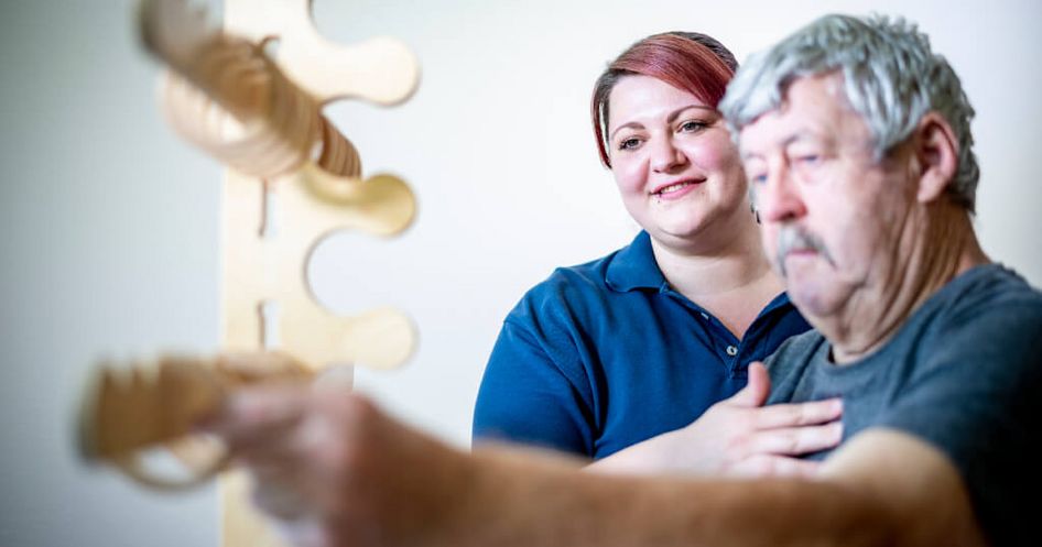 Ergotherapeutin übt mit Patient Feinmotorik Ergotherapeutin übt mit Patient Feinmotorik