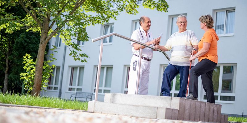 Therapeuten und Ärzte unterstützen Patienten in der Gehtherapie