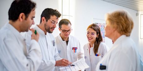 Eine Gruppe von Ärztinnen und Ärzten analysiert gemeinsam eine EKG-Grafik