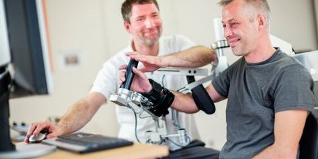 Patient trainiert mit einer Armschiene