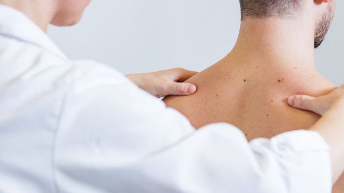 Arzt prüft Rücken des Patienten