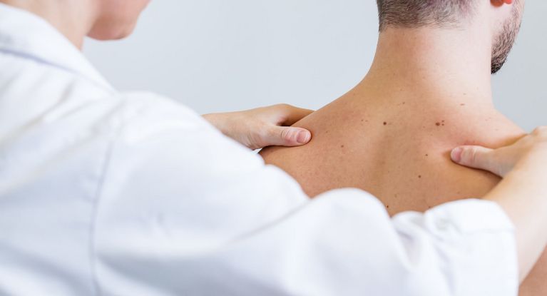 Arzt prüft Rücken des Patienten