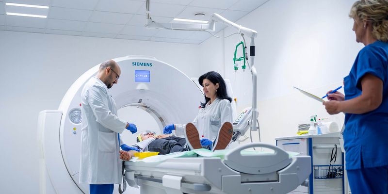 Arzt und Pflegekraft bereiten Patienten auf CT-Scan vor