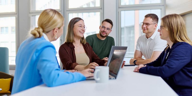 Junge Menschen sitzen zusammen im Büro und besprechen ein Projekt