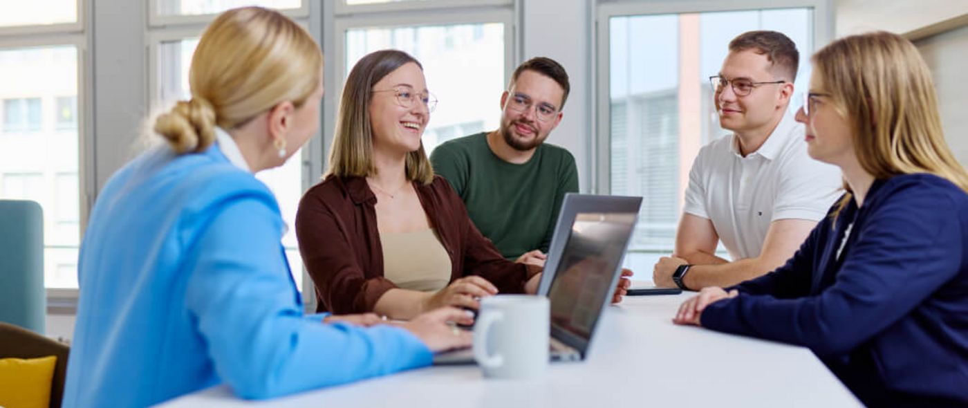 Junge Menschen sitzen zusammen im Büro und besprechen ein Projekt